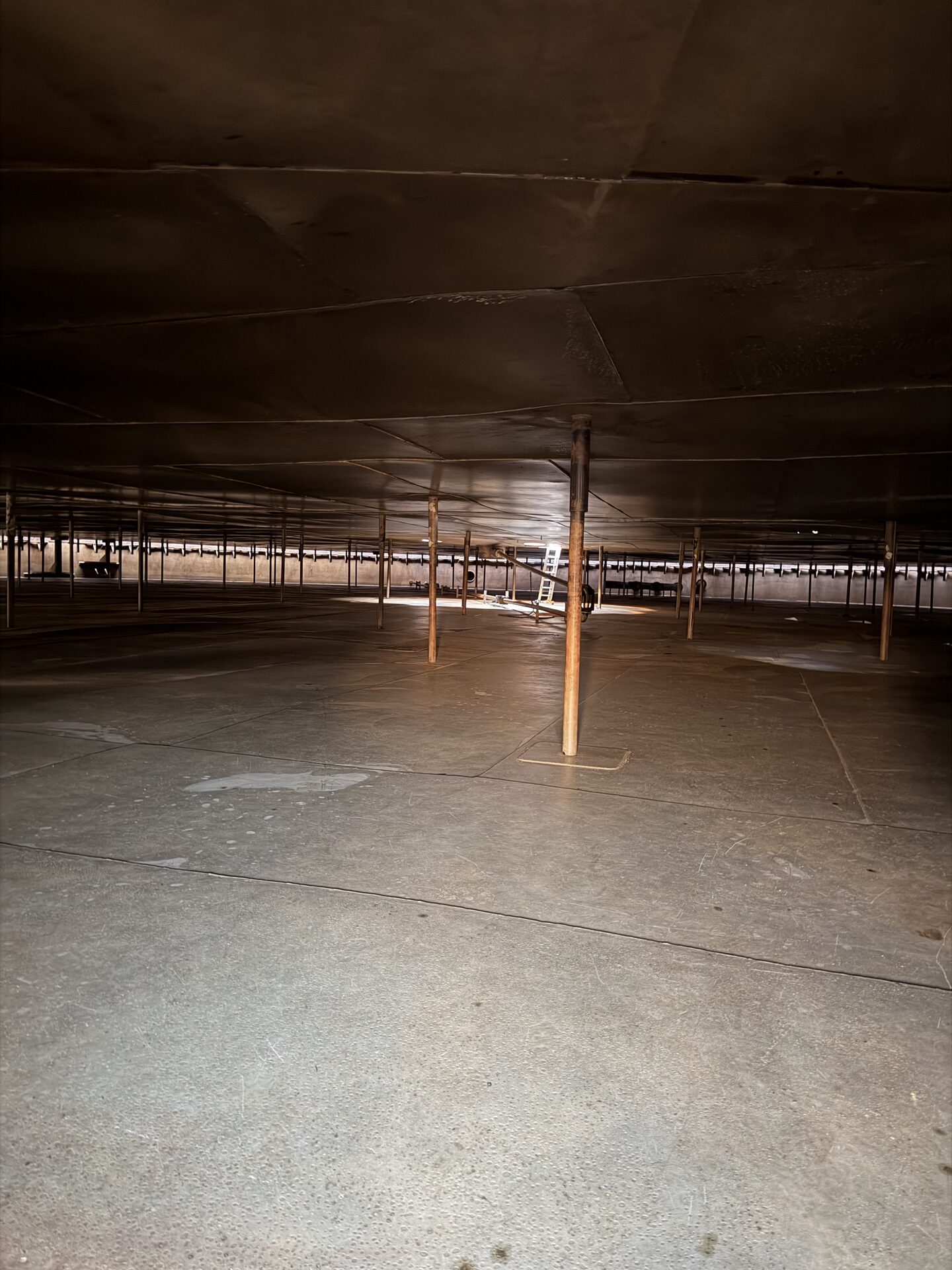 Tank interior before cleaning, with hydrocarbon residue and structural supports